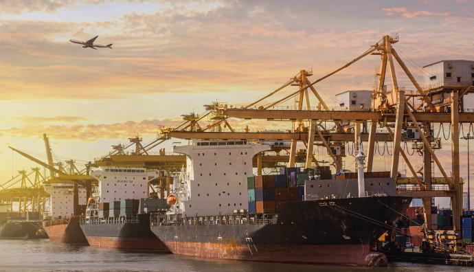 Container ships in port at sunset and aircraft in the sky | Seacon Logistics