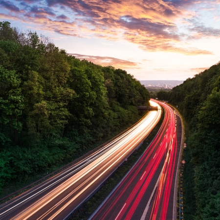 Road traffic next to forested area with sunrise | Seacon Logistics